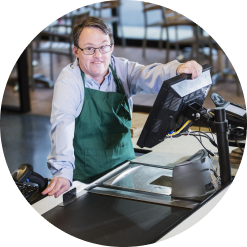 young man with Down syndrome working behind a cash register at a grocery store
